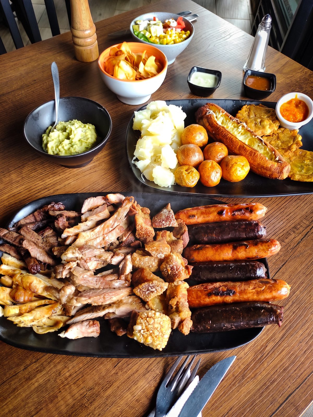 Picada para compartir con carne, chicharrón, chorizo, morcilla, papa criolla, yuca y guacamole